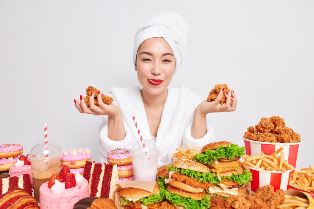 Satisfied woman with red lipstick holding fast food