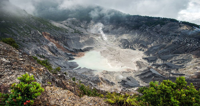 Kawah Gunung Tangkuban Perahu dengan asap yang keluar dari tanah.