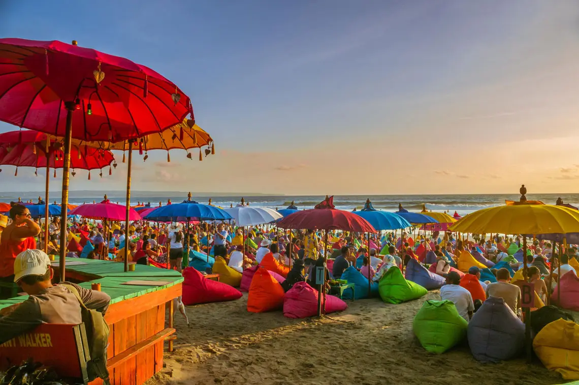 Suasana sunset di La Plancha Beach Bar Bali dengan bean bags warna-warni, tempat Instagramable untuk menikmati sore