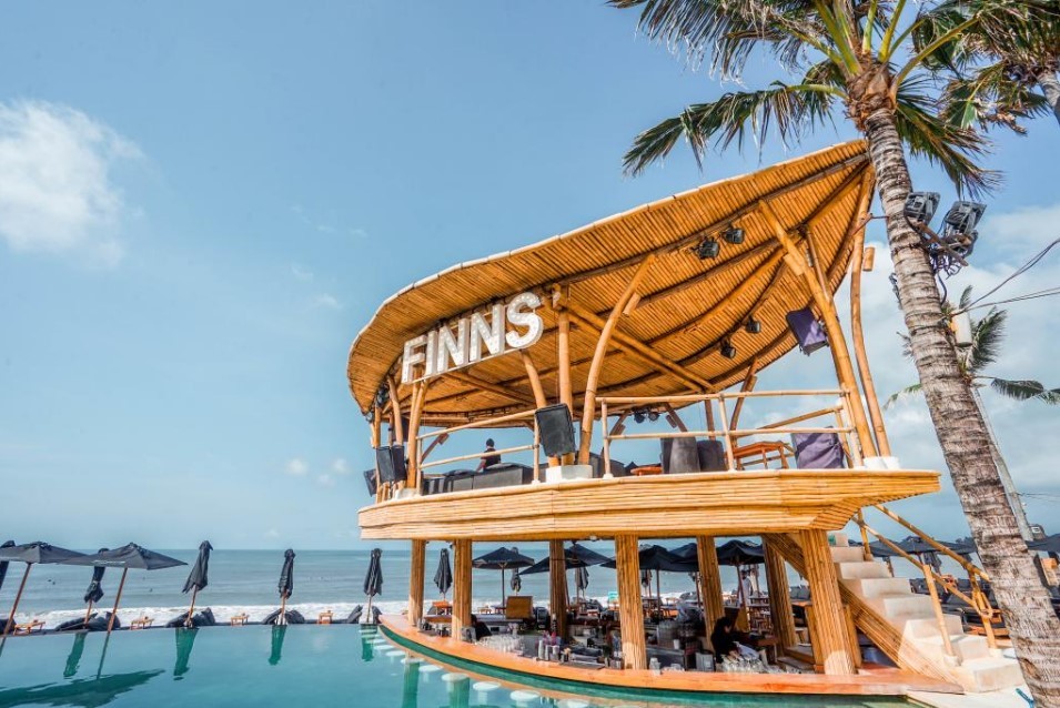 Kolam renang infinity di Finns Beach Club Bali dengan pemandangan sunset yang Instagramable