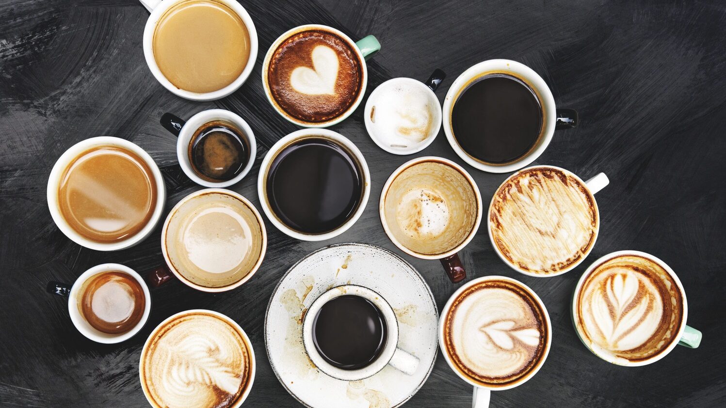 Jenis minuman kopi seperti espresso, latte, dan cappuccino tersaji dalam cangkir berbeda di atas meja kayu