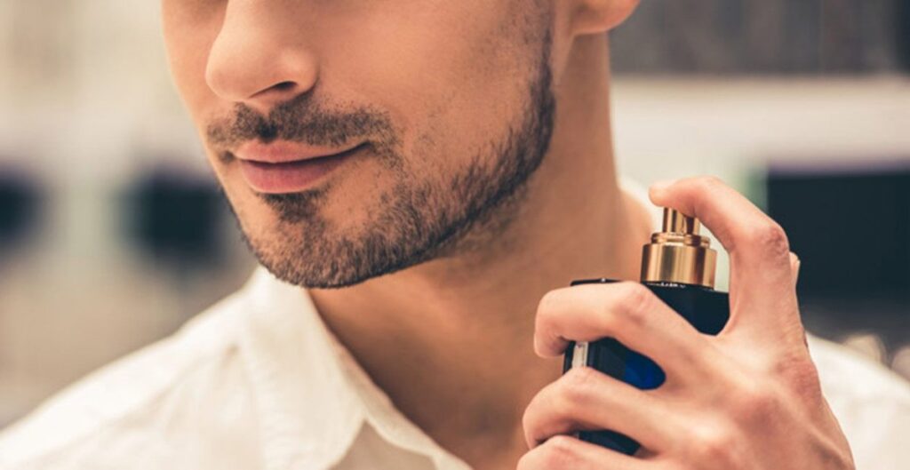 Pria memakai parfum pria maskulin dengan cara menyemprotkan ke leher