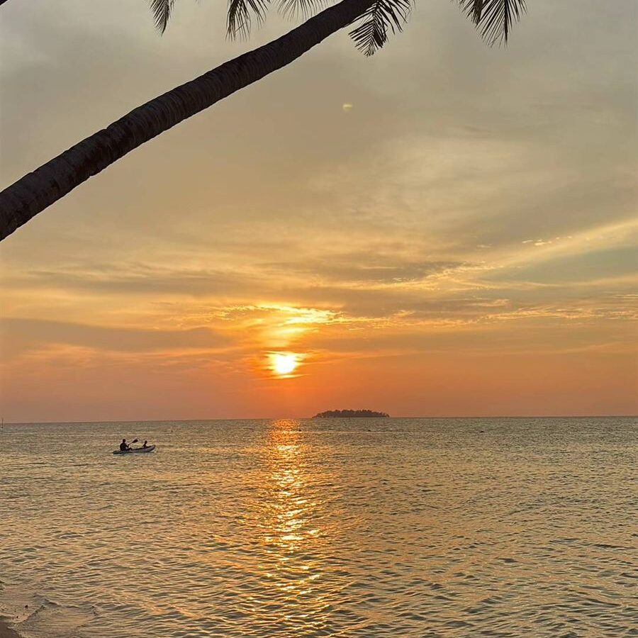 Sunset di Karimunjawa dengan langit jingga keemasan dan pantulan cahaya matahari di laut yang tenang.