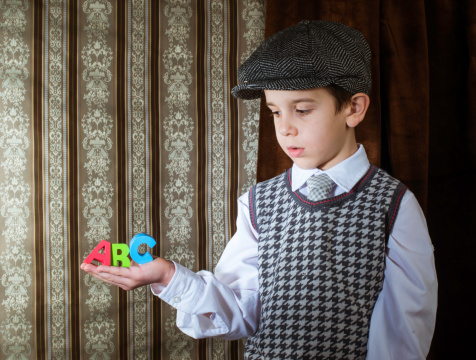 Anak memegang simbol huruf. Sumber : https://www.istockphoto.com/id/foto/anak-dengan-pakaian-vintage-memegang-huruf-a-b-c-gm478855609-36085650